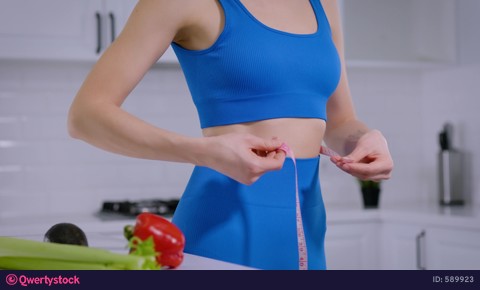 Close-up. Thin woman in sportswear measures her waist. Slimming, healthy eating video 589923